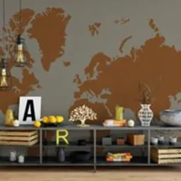 Szara ściana z brązową mapą świata, pod nią niski metalowy regał z dekoracjami: drewniane skrzynki, owoce, litery A i R, ozdobne drzewko, wazony i lampy wiszące w stylu industrialnym.