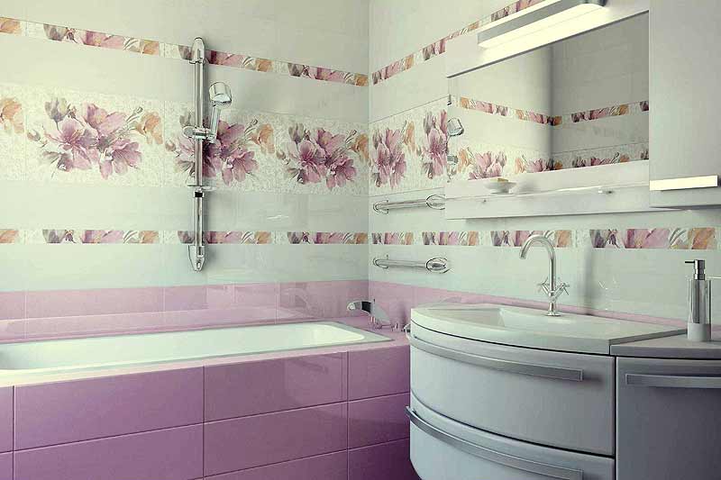 Wykończona łazienka z wanną obłożoną różowymi płytkami, ściany z białymi płytkami zdobionymi motywem kwiatowym, umywalka w zabudowie z zaokrąglonymi szufladami i chromowaną armaturą, oraz lustro...