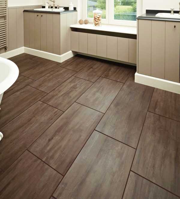 Ułożona podłoga z płytek imitujących drewno w łazience, z widocznymi szafkami pod umywalkami i oknem z dekoracjami.