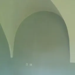 Wnętrze po malowaniu z łukowym sufitem w odcieniach szarości i błękitu, widoczne gniazdka elektryczne i karton na podłodze.