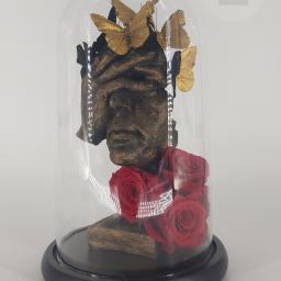 Beata Borgus BB Florist Pracownia Florystyczna Beata Borgus - Szklana kopuła z rzeźbą głowy z zasłoniętymi oczami, złotymi motylami i czerwonymi różami.