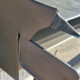 CuDACH Marcin Cuderski - Szczegółowe ujęcie na nową, ciemną obróbkę blacharską dachu, z widocznym fragmentem rynny i łączenia elementów.