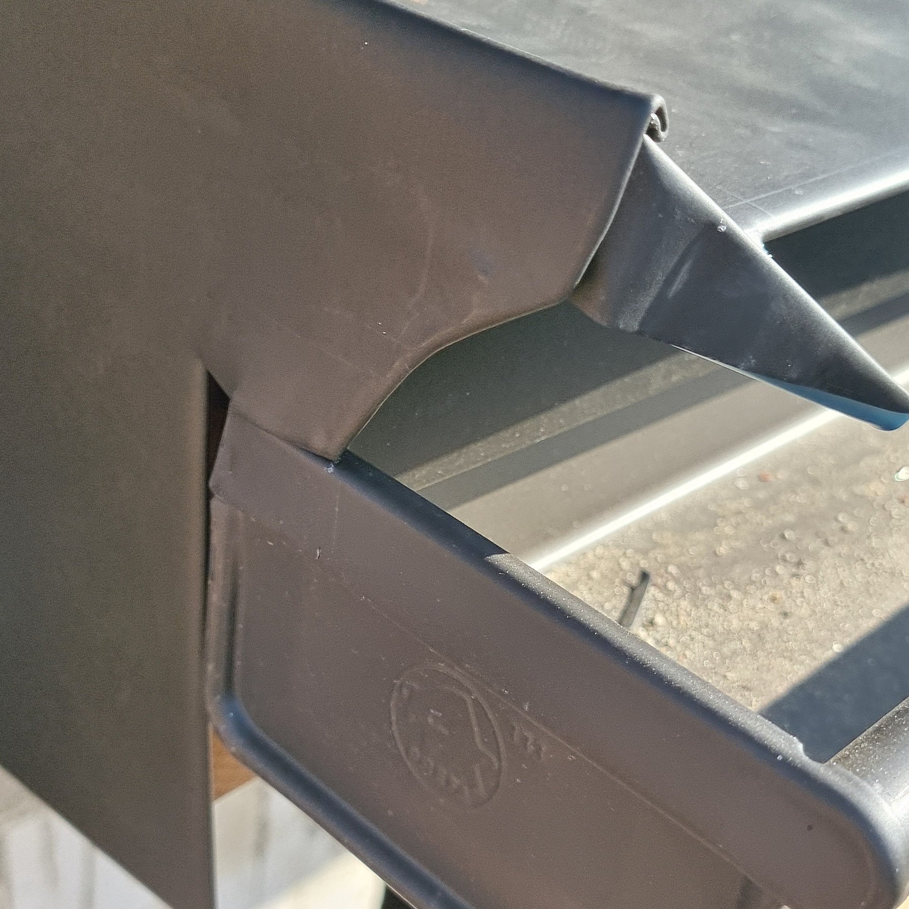 Szczegółowe ujęcie na nową, ciemną obróbkę blacharską dachu, z widocznym fragmentem rynny i łączenia elementów.