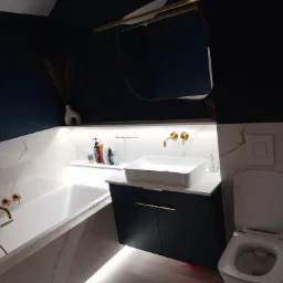 Elegancka łazienka w ciemnych tonacjach z białymi marmurkowymi płytkami, podświetleniem LED pod wanną i szafką umywalkową, oraz złotą armaturą i asymetrycznym lustrem.