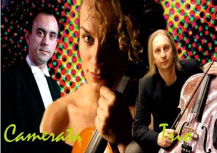 Promocyjne zdjęcie zespołu muzycznego Camerata Tulis z trzema członkami: mężczyzna w smokingu, kobieta z skrzypcami i mężczyzna z wiolonczelą na tle kolorowego wzoru.