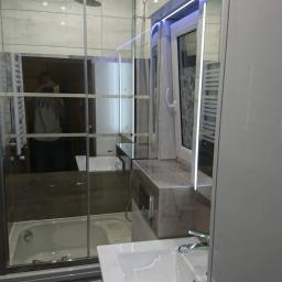 ANDRE - MONT Andrzej Strembicki - Nowoczesna łazienka z kabiną prysznicową typu walk-in, umywalką nablatową i oświetleniem LED, widoczna w lustrzanym odbiciu osoba robiąca zdjęcie.