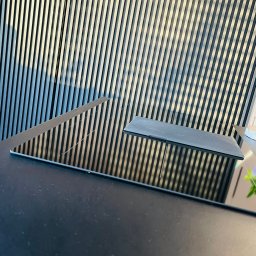 MTD MEBLE Tomasz Dąbrowski - Czarny, błyszczący blat kuchenny z indukcyjną płytą, odbijający pionowe lamele na ścianie. Minimalistyczny design, nowoczesne wykończenie.