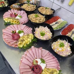 AgawaHouse - Dekoracyjne półmiski wędlin i sałatki w czarnych miskach, gotowe do serwowania. Widoczne plastry szynki, ser, pomidory i ogórki. Profesjonalny catering.