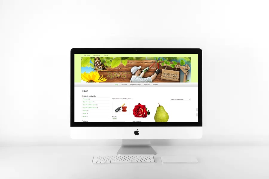 Ekran komputera iMac wyświetlający stronę sklepu internetowego z artykułami ogrodniczymi, na stronie głównej widoczne kategorie produktów, ilustracje narzędzi, róży i gruszki.