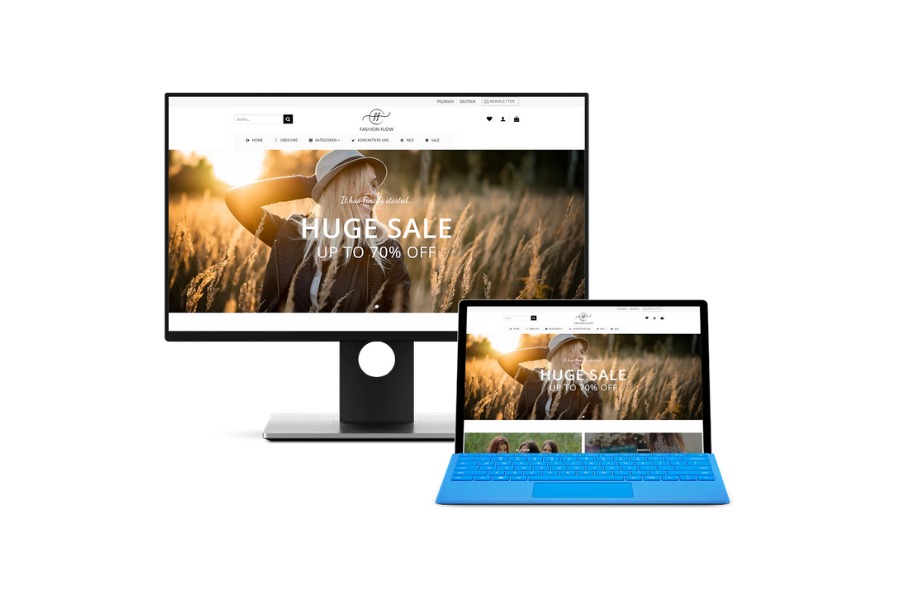 Ekran monitora i laptopa wyświetlają stronę internetową sklepu odzieżowego z promocją do 70% z kobietą w kapeluszu na tle pola pszenicy w promieniach zachodzącego słońca.