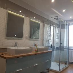 PRO-100 Krzysztof Gajewski - Nowoczesna łazienka z dwoma umywalkami nablatowymi na szafce z szufladami w odcieniach błękitu, kabina prysznicowa ze szklanymi drzwiami, płytki ceramiczne z falistym wzorem na ścianach...