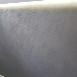 PRO-100 Krzysztof Gajewski - Szara ściana z dekoracyjną, chropowatą fakturą i delikatnym oświetleniem górnym LED.