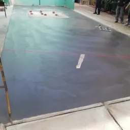 Wylewka betonowa w hali produkcyjnej, z widocznymi elementami szalunku i poziomowania laserowego, przygotowana do dalszych prac wykończeniowych.