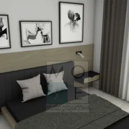 Nowoczesna sypialnia z czarnym łóżkiem, drewnianym panelem zagłówka, minimalistycznymi lampkami nocnymi i trzema czarno-białymi fotografiami na ścianie.