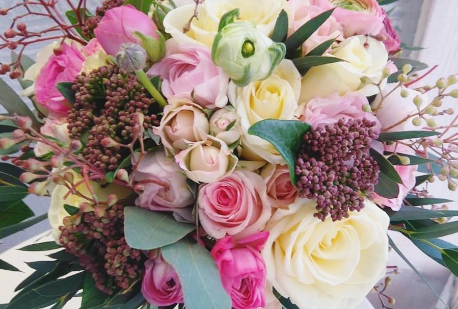 Delikatny bukiet ślubny z białych i różowych róż, tulipanów oraz brunii, z bliska.