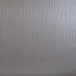 Krzysztof - Ściana pokryta białą, strukturalną tapetą z falistym wzorem, przylegająca do drewnianej boazerii.