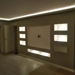 Wykończony salon z podświetlaną ścianą z płyty karton gips z wnękami, oświetleniem LED na suficie i jasną podłogą.