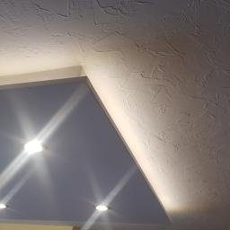 Zmaźlok - Wykończony sufit z oświetleniem punktowym i dekoracyjną strukturą, widok z dołu.