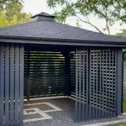 Nowoczesna, szara konstrukcja z dachem krytym dachówką bitumiczną w Jeziornie, z elementami ażurowymi i geometrycznym wzorem na posadzce.