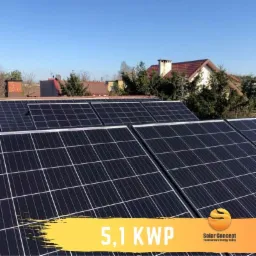 Panel słoneczny o mocy 5,1 kWp zamontowany na dachu domu jednorodzinnego, widok z góry, błękitne niebo w tle.