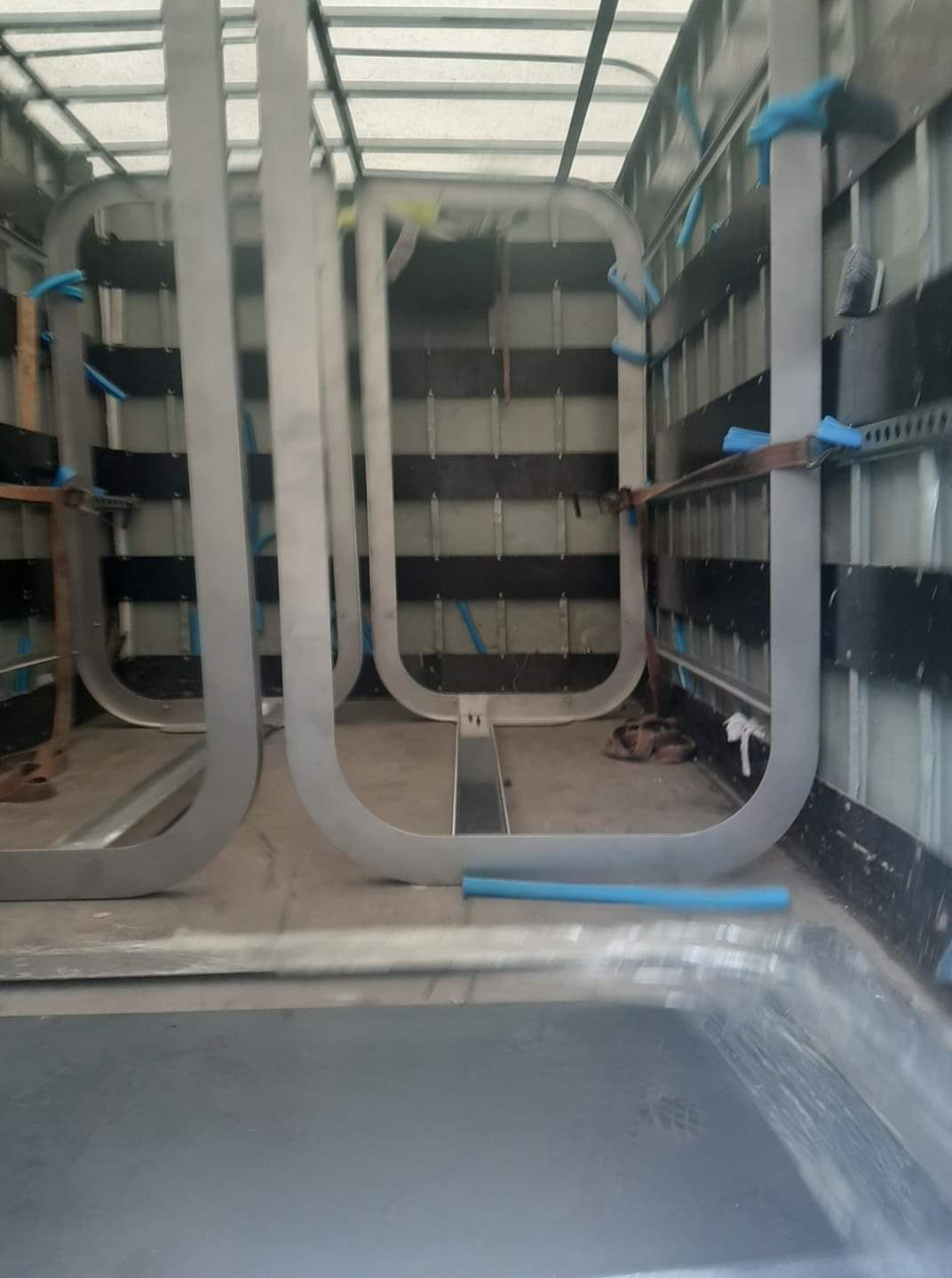 Metalowe ramy wewnątrz pojazdu, zabezpieczone niebieską pianką, wykonane w Gliwicach. Widoczne elementy konstrukcyjne i spawy.