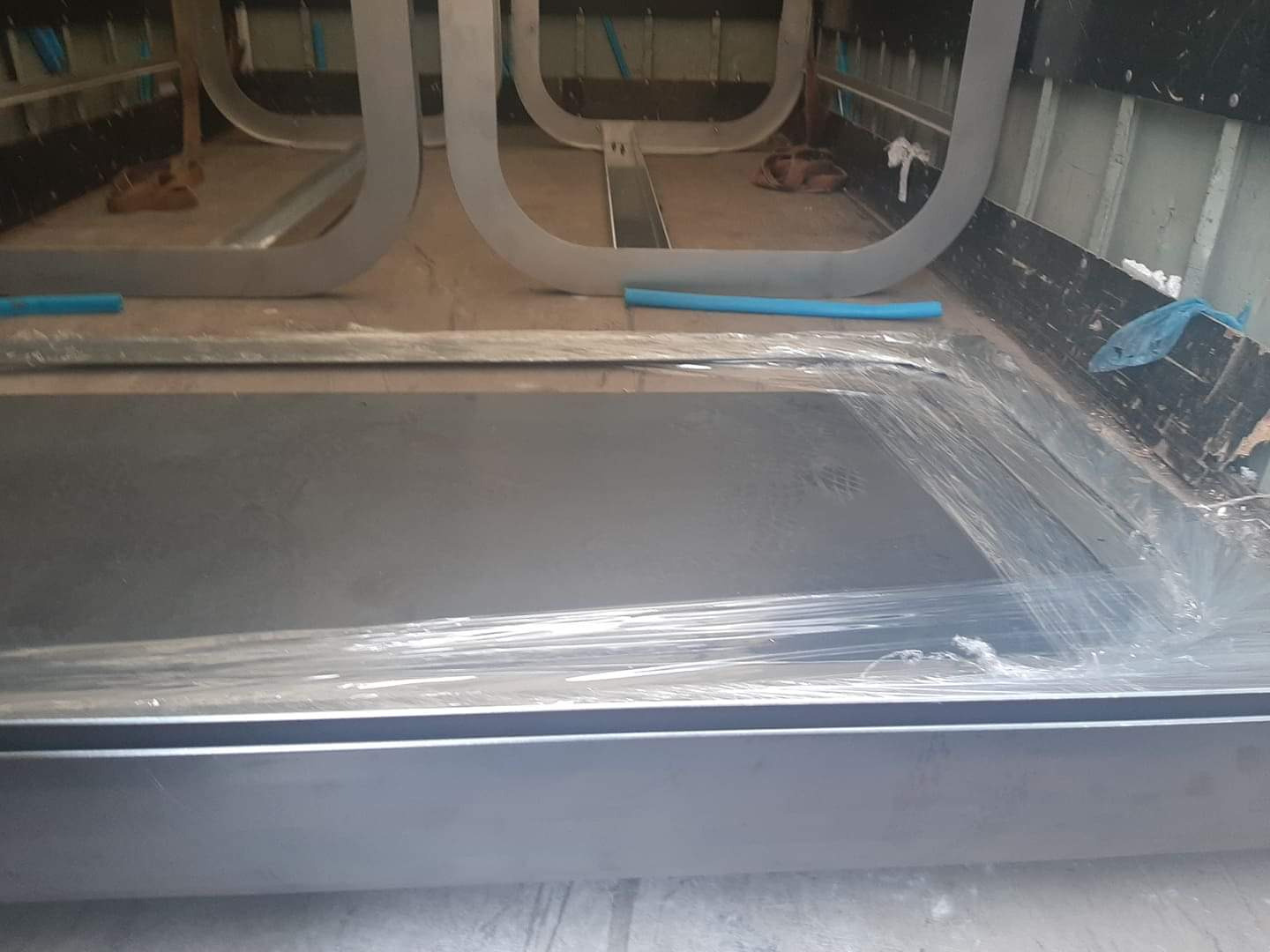 Metalowa konstrukcja w trakcie budowy, widoczne elementy spawane i przygotowane do dalszej obróbki, zabezpieczone folią.