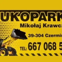Żółta tablica reklamowa firmy TUKOPARKI Mikołaj Krawczyk z ilustracją koparki, adresem i numerem telefonu.