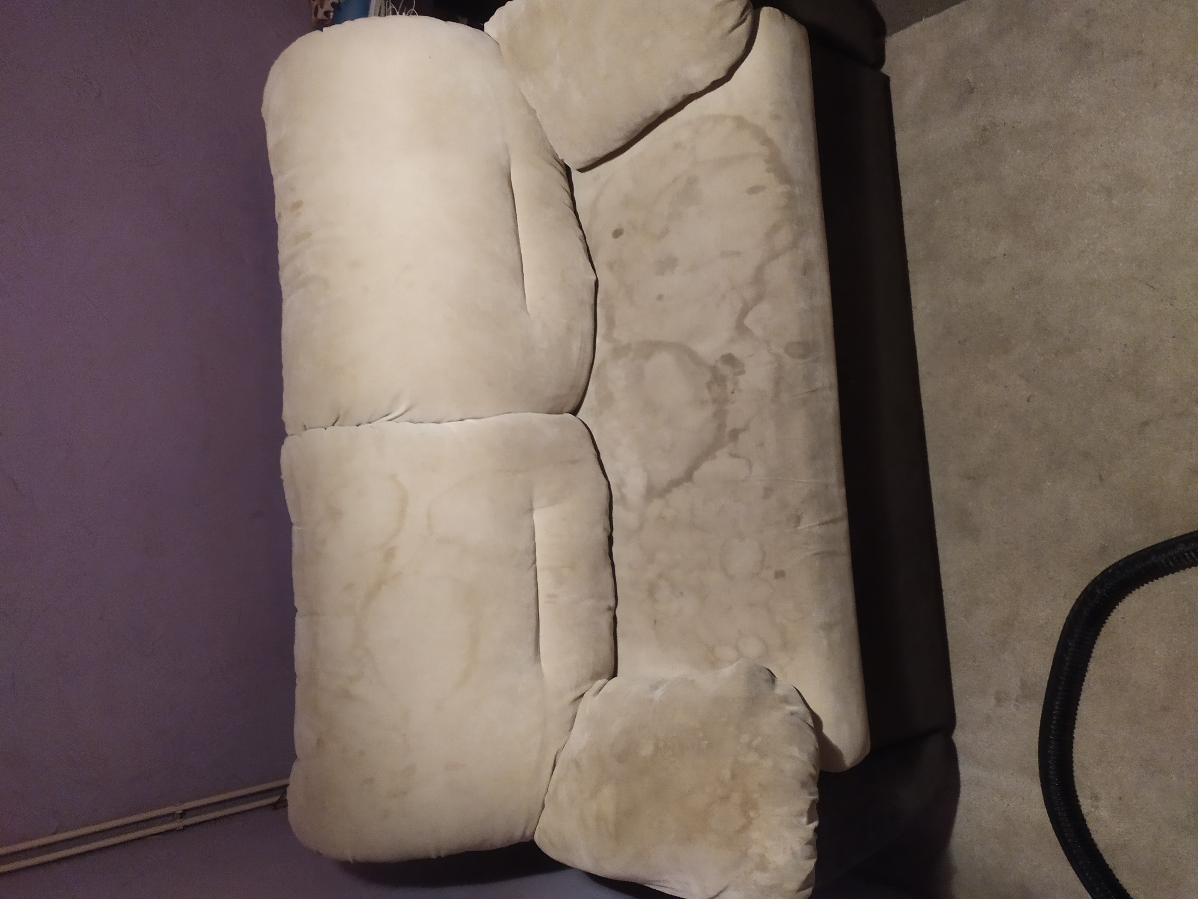 Beżowa, pluszowa sofa z widocznymi plamami na siedzisku i oparciu, ujęcie z góry.