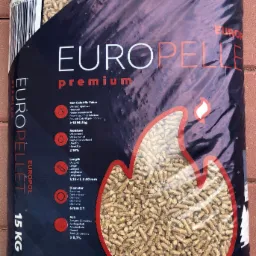Worek 15 kg z pelletem drzewnym marki Europellet Premium, widoczny przez przezroczyste okienko na tle ceglanej ściany.