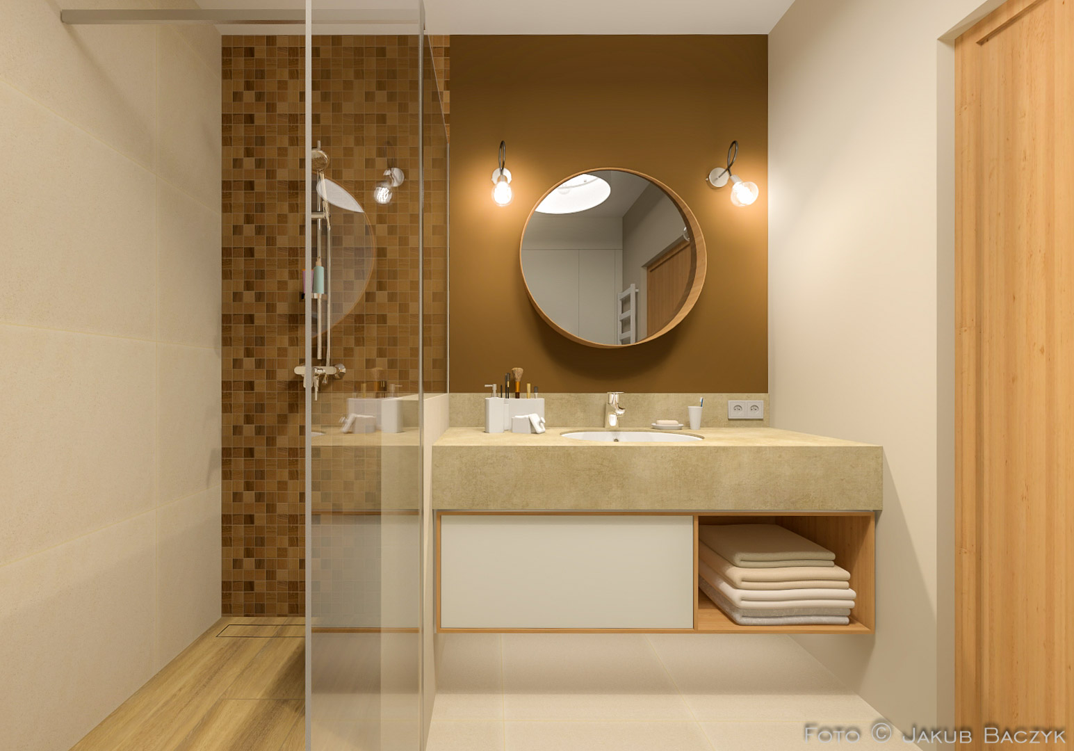 Nowoczesna łazienka z kabiną prysznicową typu walk-in, umywalką nablatową na beżowym blacie z szafką i okrągłym lustrem podświetlonym kinkietami.