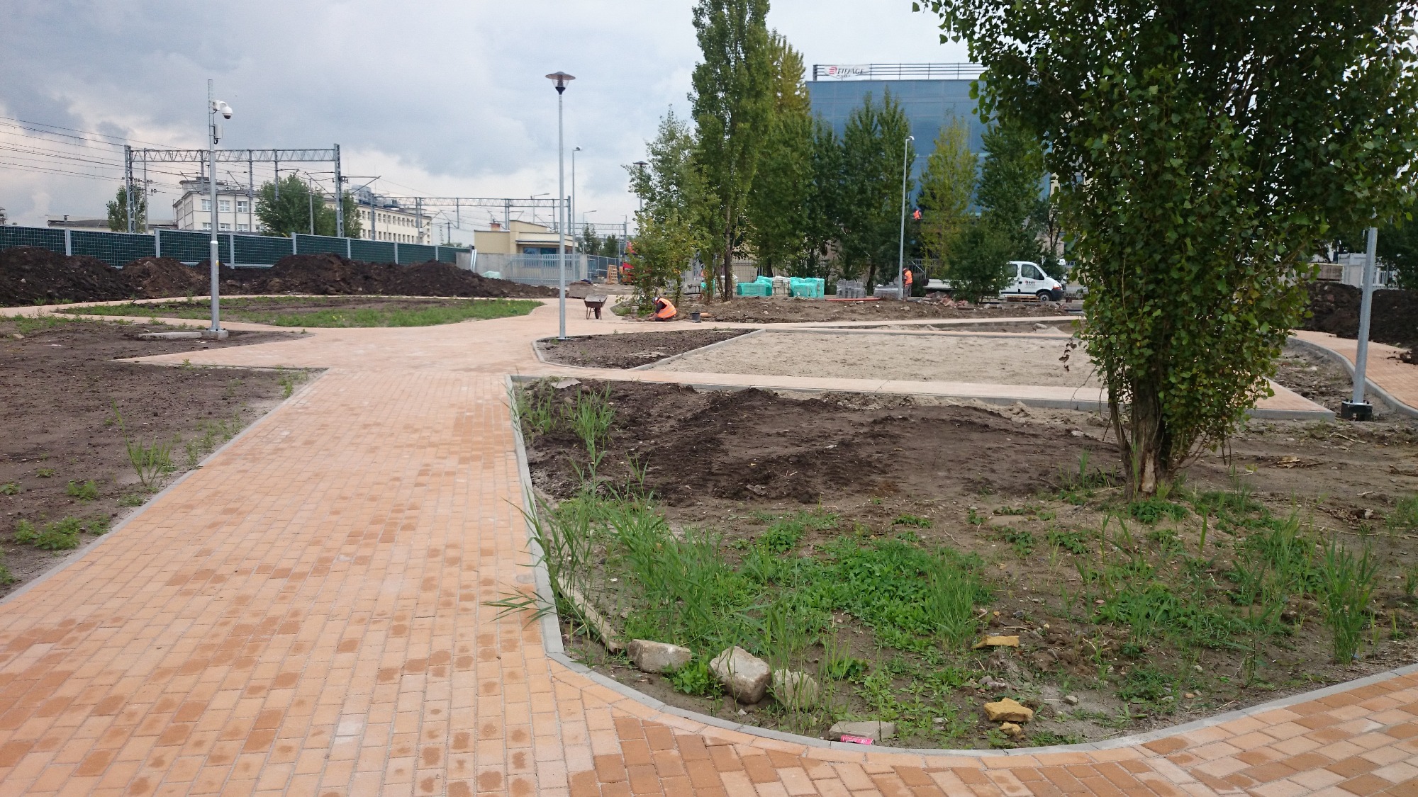 Układanie kostki brukowej w Witobelu: widok na nowo powstający park z alejkami z kostki, w tle prace ziemne i przygotowanie terenu pod nasadzenia.