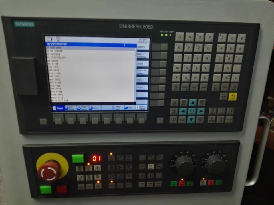 Panel sterowania numerycznego SINUMERIK 808D z widocznym ekranem z listą programów, klawiaturą alfanumeryczną i przyciskiem bezpieczeństwa.