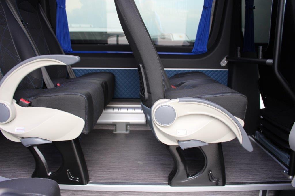 Wnętrze busa turystycznego: komfortowe fotele Novis z pełną regulacją, pasami bezpieczeństwa, podłokietnikami, siateczkami, stolikami, rączkami i zagłówkami, montowane na podestach z szynami.