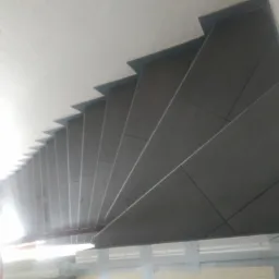 Wykończone schody wewnętrzne z ciemnoszarymi płytkami, widok z g&oacute;ry, z widocznym podświetleniem u dołu.