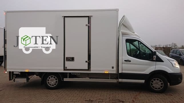 Biały samochód dostawczy z nadrukowanym logo firmy 'JOTEN' na boku, zaparkowany na brukowanym placu.