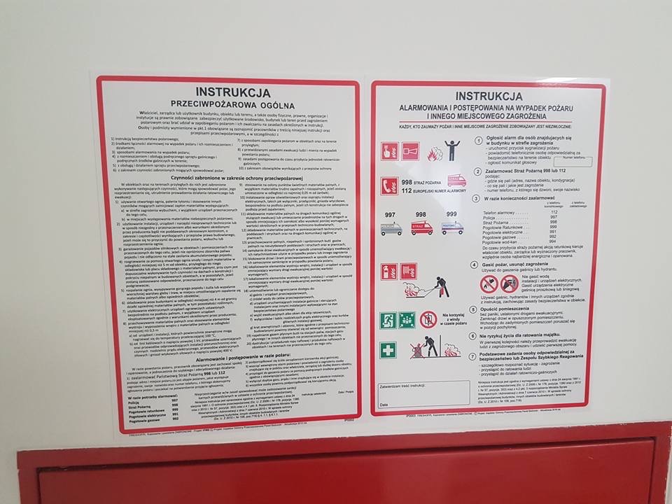Dwie instrukcje: przeciwpożarowa ogólna i alarmowania w razie pożaru, z numerami alarmowymi i zasadami postępowania, umieszczone obok siebie na białej ścianie.