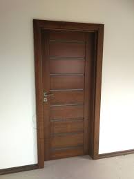 Ciemnobrązowe drzwi wewnętrzne z poziomymi panelami i srebrną klamką, zamontowane w białej ścianie.