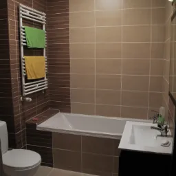 Ukończona łazienka z brązowo-beżowymi płytkami, białą wanną, toaletą i umywalką z czarną szafką, grzejnik drabinkowy z zielonym i żółtym ręcznikiem.