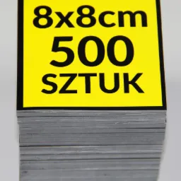 Stos 500 sztuk naklejek w formacie 8x8cm z czarnym obramowaniem i żółtym tłem, na którym widnieje czarny napis.
