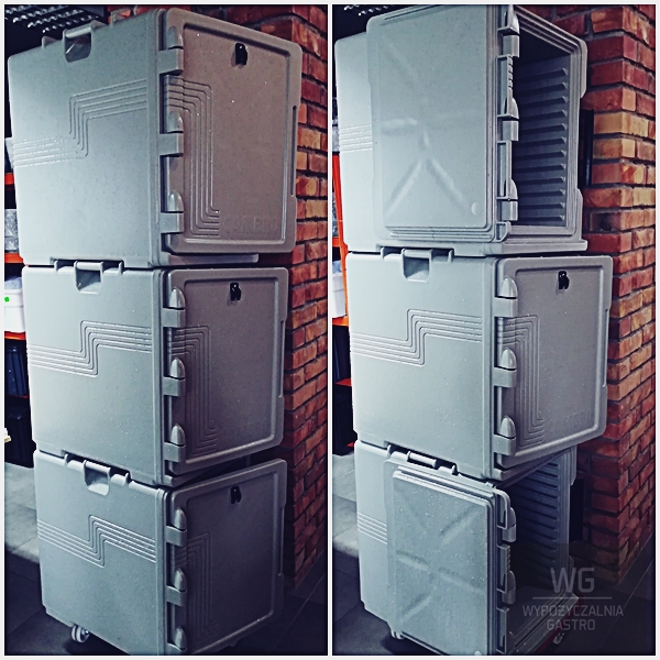 Stos szarych, izolowanych pojemników gastronomicznych na kółkach, ustawionych w pionie obok ceglanej ściany. Widoczne uchwyty i zatrzaski. Jeden pojemnik otwarty, ujawniający wnętrze z półkami.