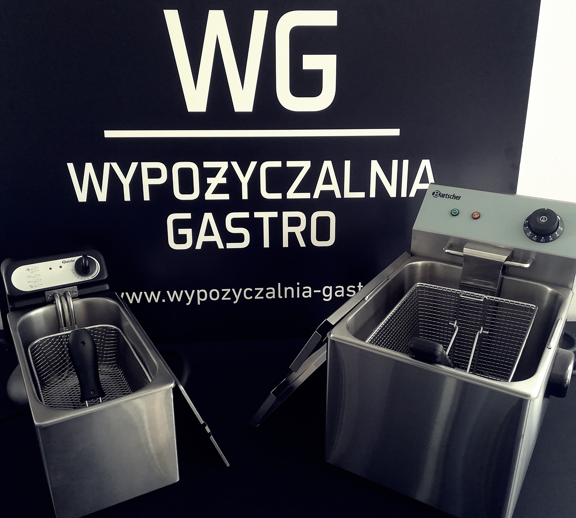 Dwie frytownice marki Bartscher na tle baneru reklamowego wypożyczalni sprzętu gastronomicznego z Białegostoku.