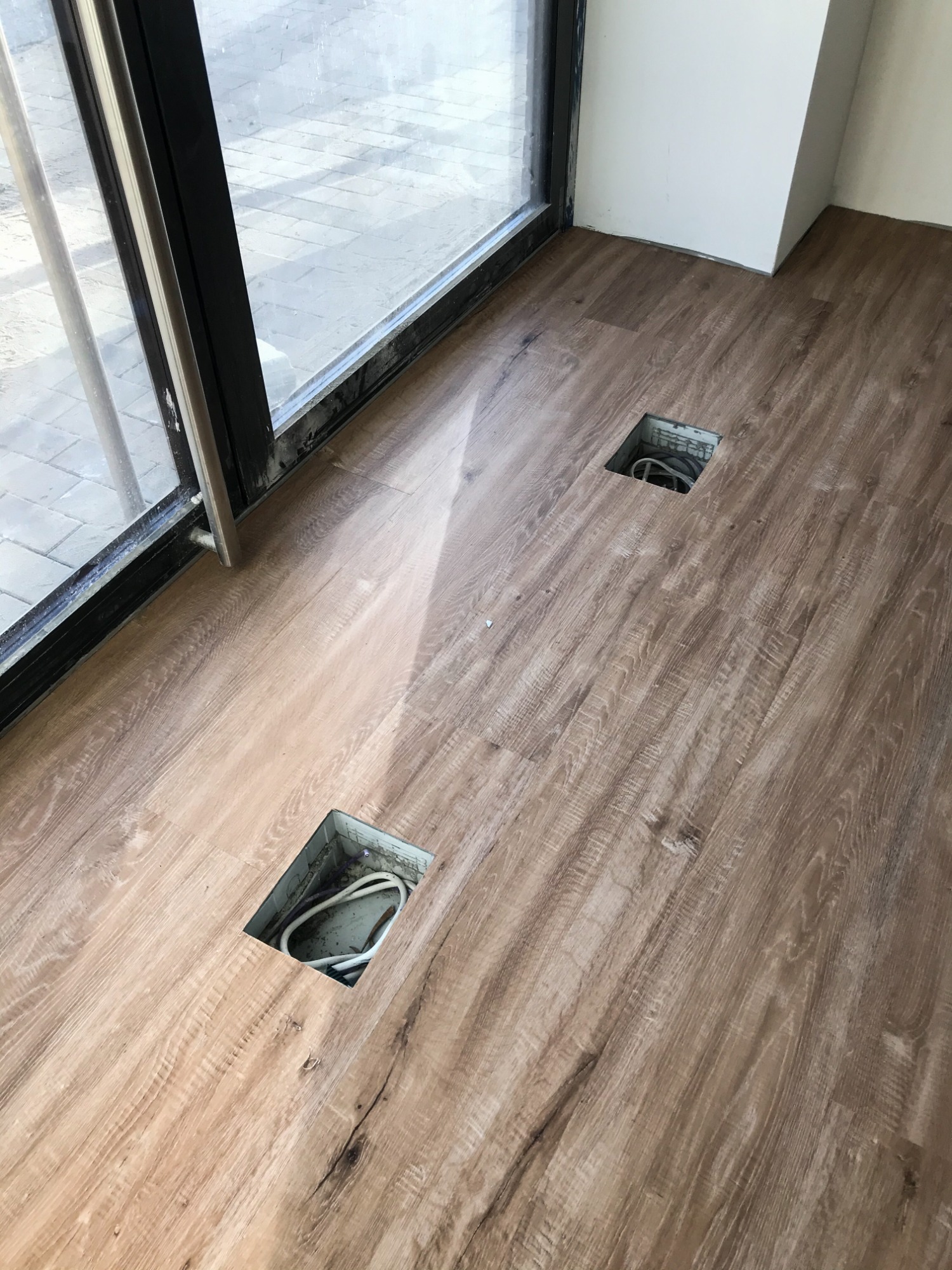 Podłoga z paneli imitujących drewno w Smardzowie, z widocznymi otworami instalacyjnymi przed wykończeniem.