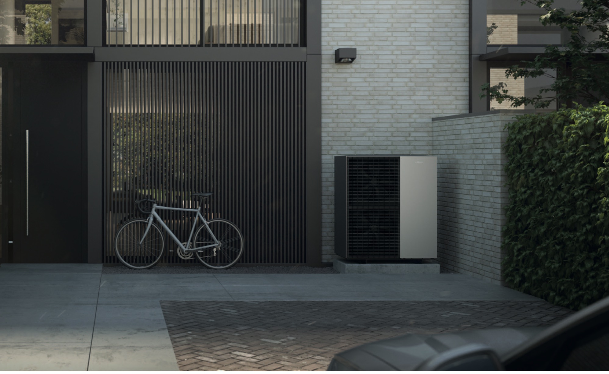 Nowoczesny dom z pompą ciepła na zewnątrz, rower oparty o ścianę, minimalistyczny design, ceglana ściana w tle