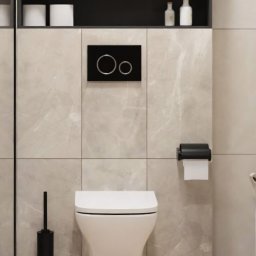 Krzysztof Błauciak - Nowoczesna, podwieszana toaleta w łazience wykończonej płytkami imitującymi marmur, z drewnianymi żaluzjami w szafkach wiszących i czarnymi akcesoriami, takimi jak szczotka do WC i uchwyt na papier...