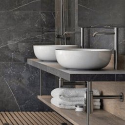 Krzysztof Błauciak - Nowoczesna łazienka z ciemnymi marmurowymi płytkami, dwiema okrągłymi umywalkami nablatowymi, minimalistyczną armaturą w kolorze czarnym, drewnianą półką z ręcznikami i drewnianą kratką...