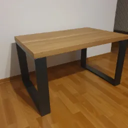 Stół z drewnianym blatem i metalowymi nogami w stylu industrialnym, wykonany na wymiar w Chechło, na podłodze panele.