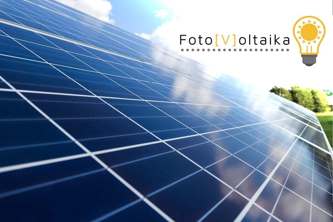 Nisko kątowe ujęcie paneli słonecznych z odblaskami nieba, w prawym górnym rogu logo firmy z żarówką.