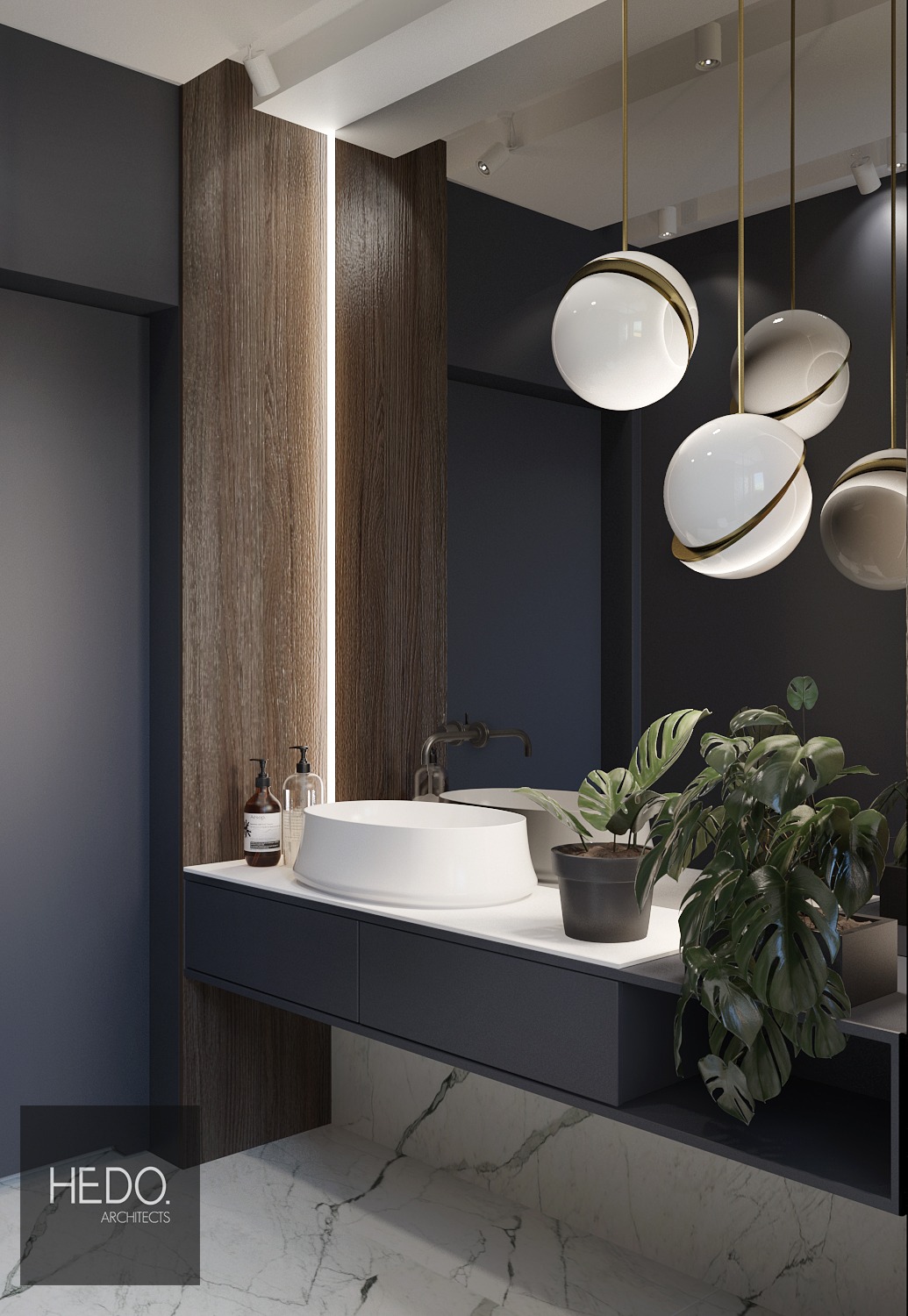 Nowoczesna łazienka z okrągłą białą umywalką nablatową, czarną armaturą, marmurową podłogą i wiszącymi lampami kulami z elementami złotymi, uzupełniona zieloną rośliną doniczkową.