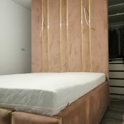 Łóżko sypialniane ze ścianą tapicerowaną. 