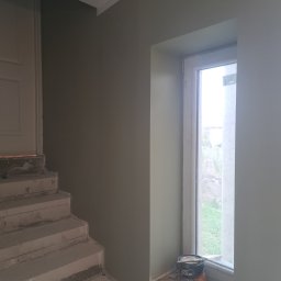Rem-Bar - Świeżo pomalowane na oliwkowo ściany w Będzinie, widoczne schody w surowym stanie i puszka farby Dulux na parapecie okna.